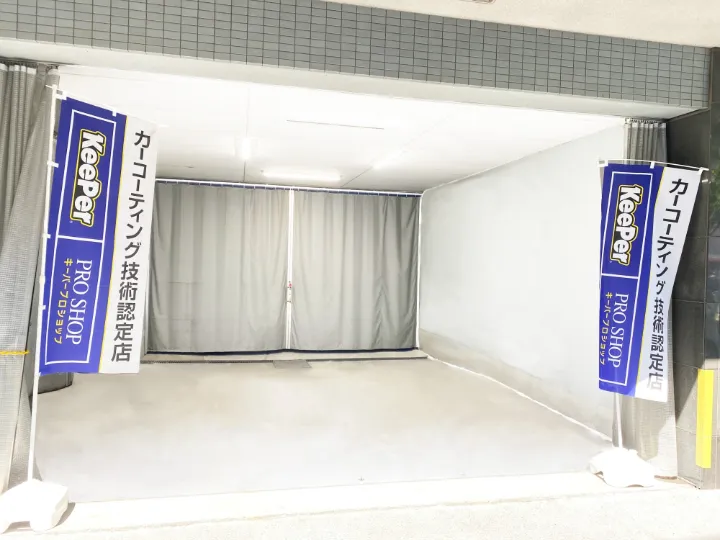足立千住店の専用施工ブース。入口にKeePer PRO SHOPののぼりが立ち、奥はカーテンで仕切られている